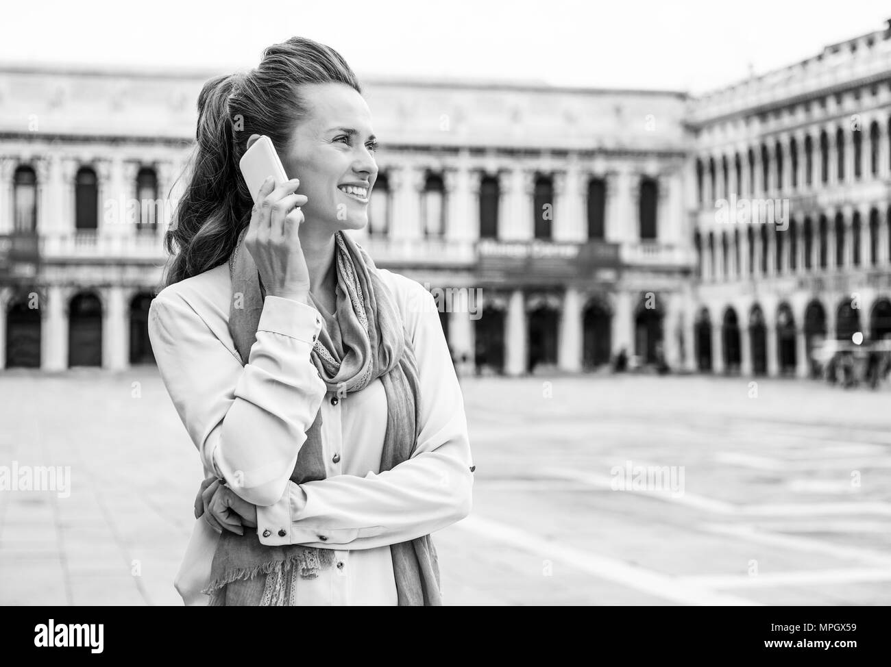 Ritratto di felice giovane donna parlando cellulare su piazza san marco a venezia, Italia Foto Stock