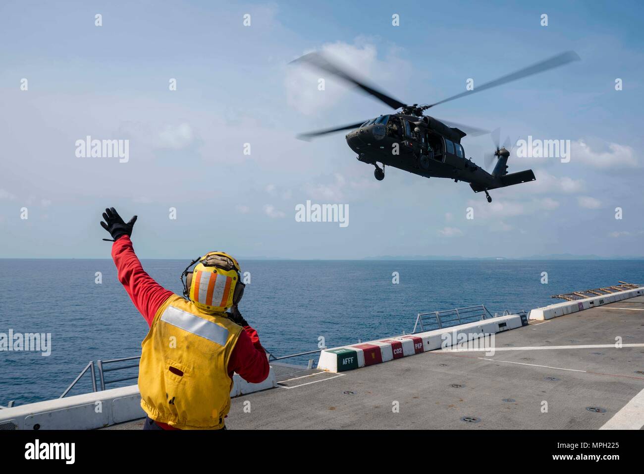 170222-N-JH293-233 Golfo di Thailandia (feb. 22, 2017) DEGLI STATI UNITI Aviazione Navale di Boatswain Mate (manipolazione) 1a classe Patrick Henry, da Pearl City, Hawaii, segnali a U.S. Esercito UH-60Q Blackhawk elicottero, assegnato al venticinquesimo combattimento Brigata Aerea, come si decolla dal ponte di volo del trasporto anfibio dock nave USS Green Bay (LPD 20) durante l'esercizio Cobra Gold 2017. Cobra Gold è il più grande teatro di cooperazione nel campo della sicurezza in esercizio il Indo-Asia-regione del Pacifico ed è parte integrante dell'impegno degli Stati Uniti per rafforzare l'impegno nella regione. (U.S. Navy foto di comunicazione di massa Foto Stock