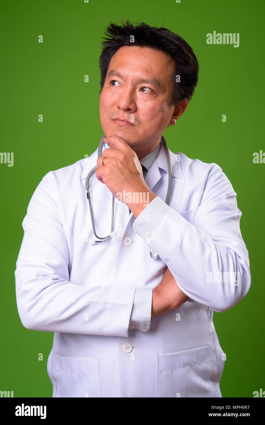 Coppia giapponese medico uomo contro lo sfondo di colore verde Foto Stock