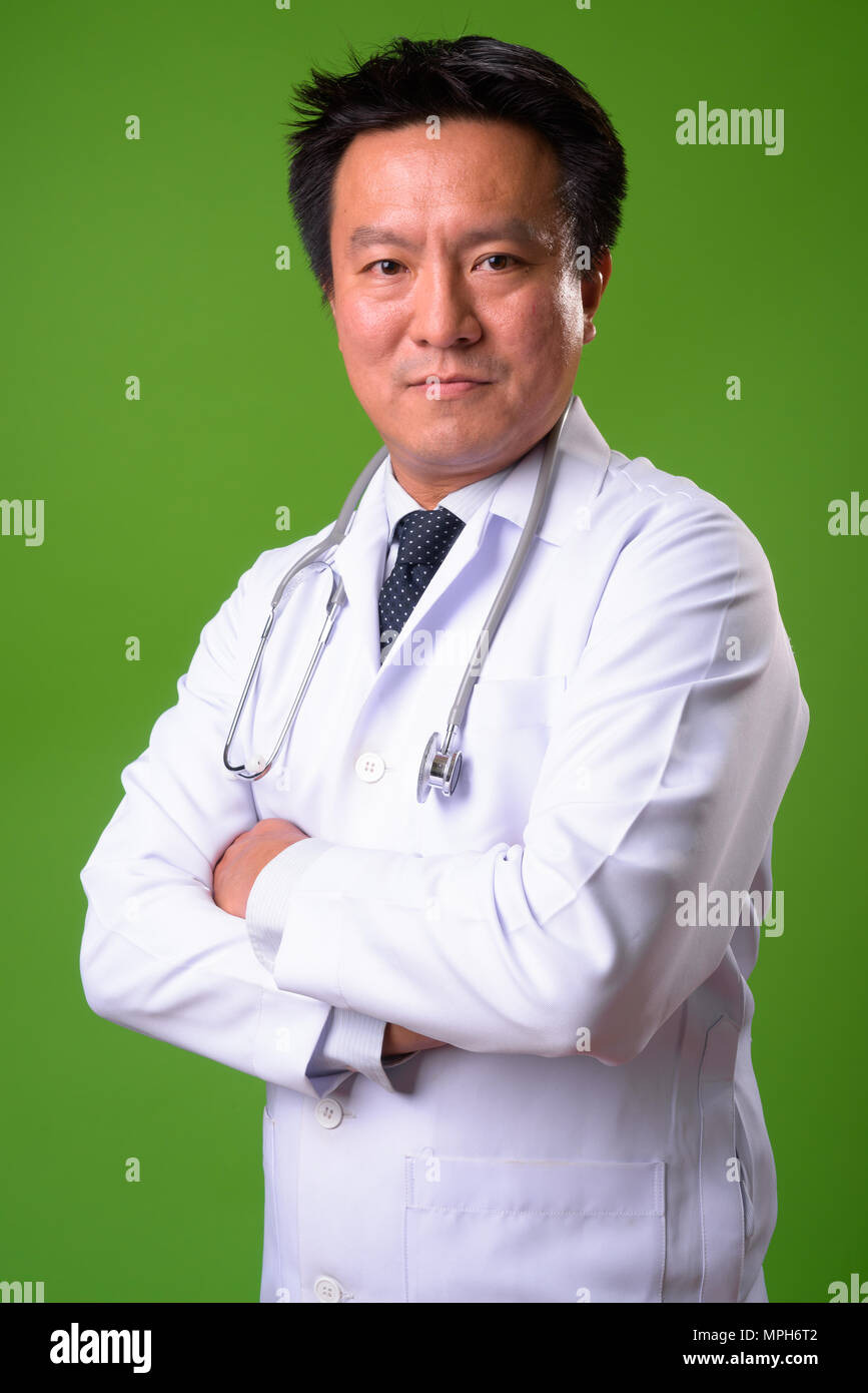 Coppia giapponese medico uomo contro lo sfondo di colore verde Foto Stock
