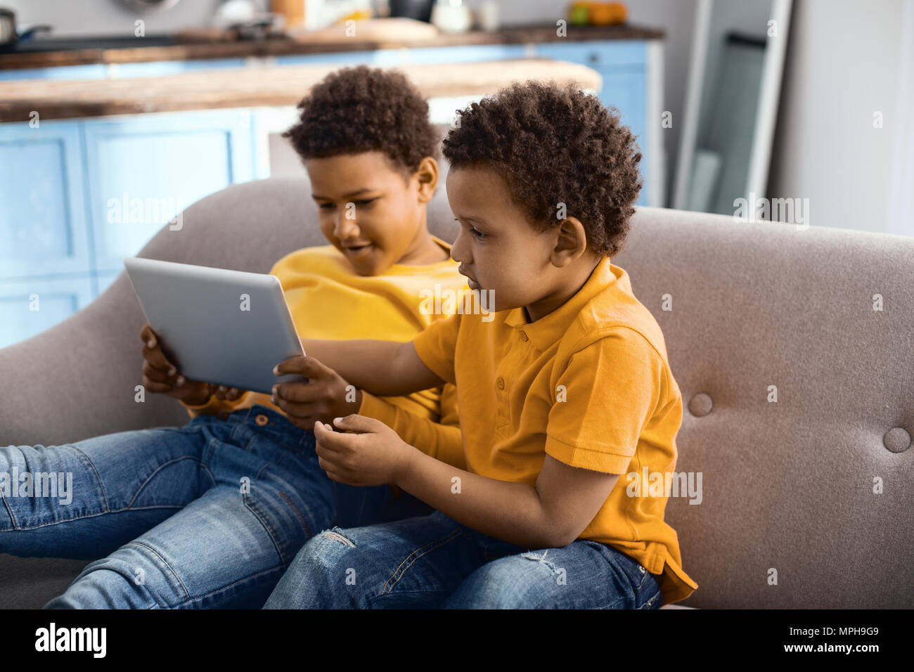 Carino piccoli fratelli guardare cartoon su tablet insieme Foto Stock