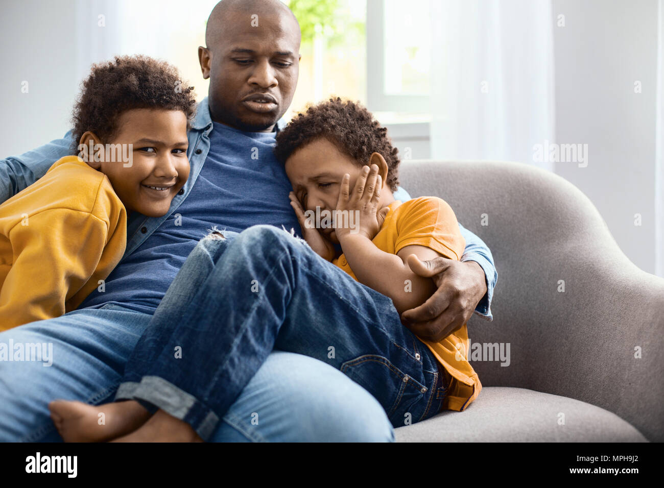 Caring giovane padre consolante suo figlio di pianto Foto Stock