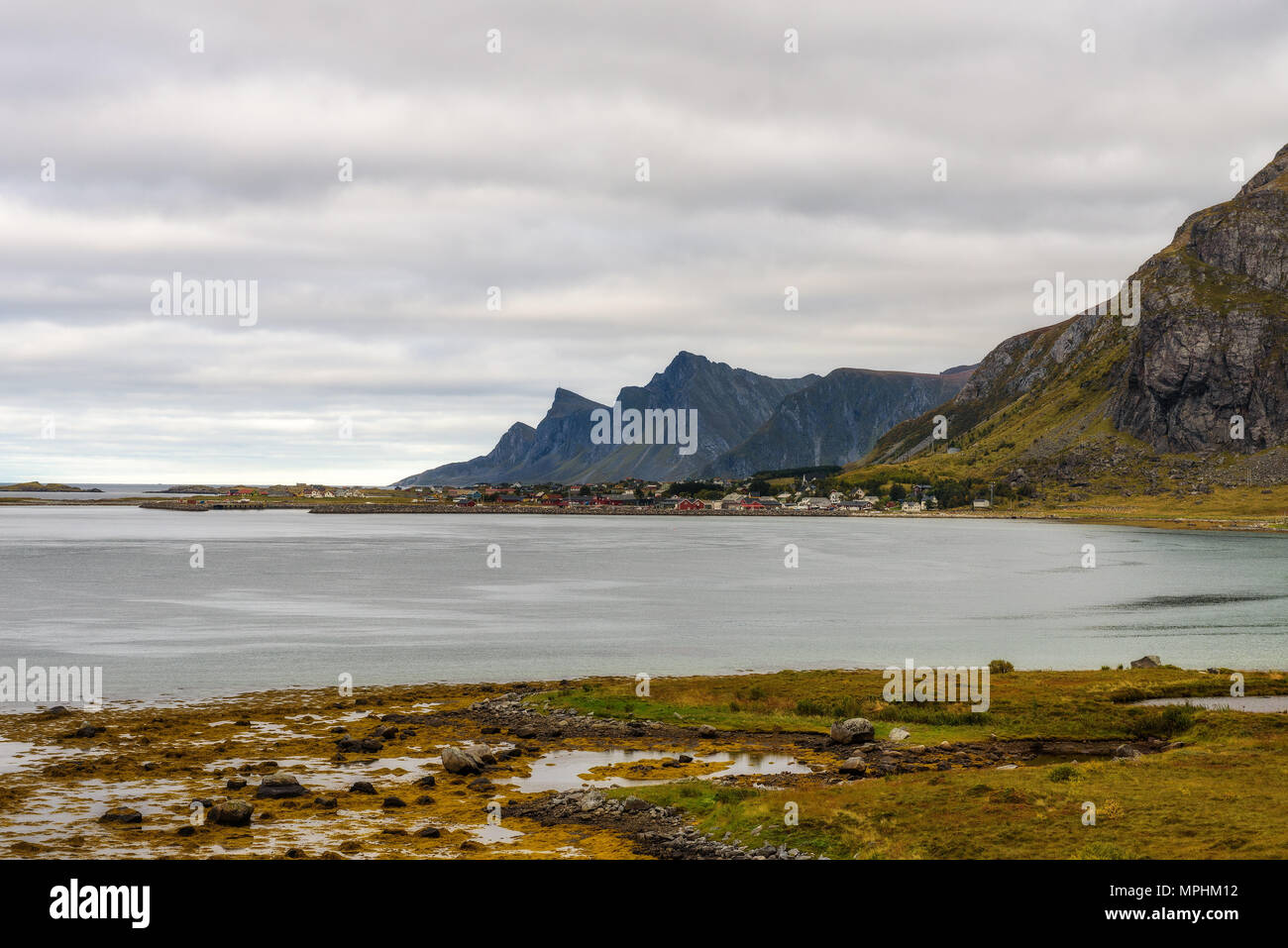 Villaggio lungo la costa e le alte montagne sulle Isole Lofoten Foto Stock
