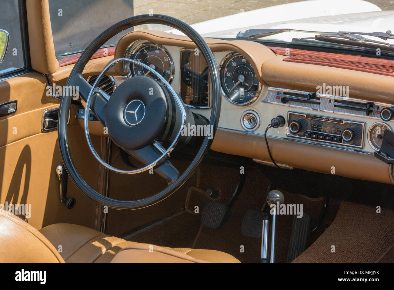 Il volante e il cruscotto di un vintage collezionisti Mercedes vettura sportiva in condizione di bello. Classico tedesco auto d'epoca in uso giornaliero per il parcheggio delle auto. Foto Stock