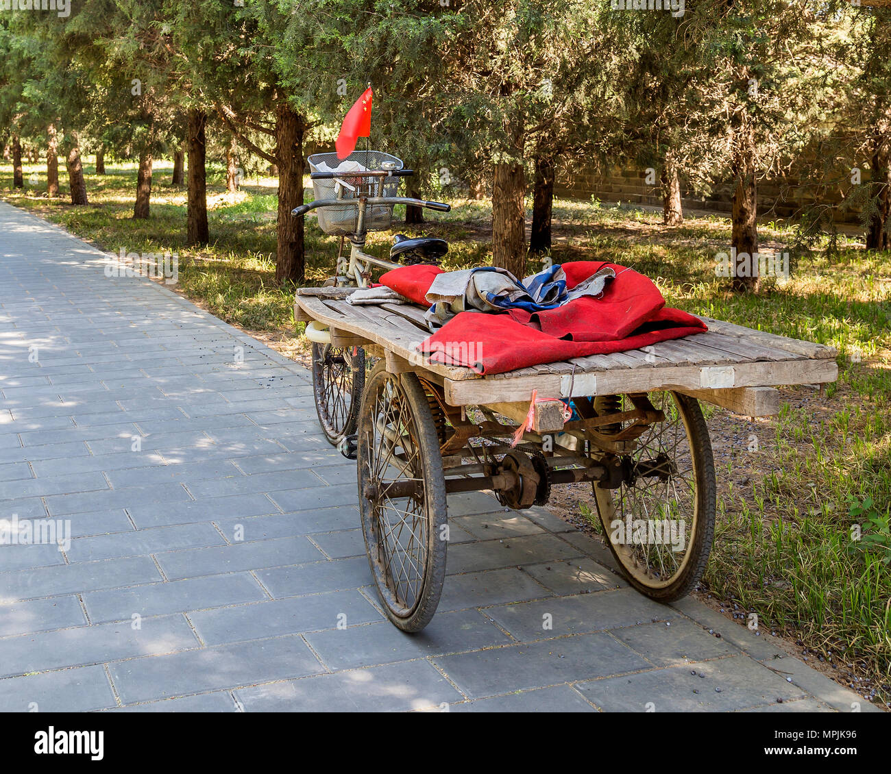 Un carrello triciclo battenti bandiera cinese a Pechino park, Pechino, Cina Foto Stock