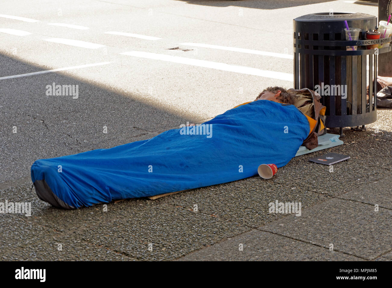 Giovani senzatetto che dorme sul marciapiede nel centro cittadino di Vancouver, BC, Canada Foto Stock