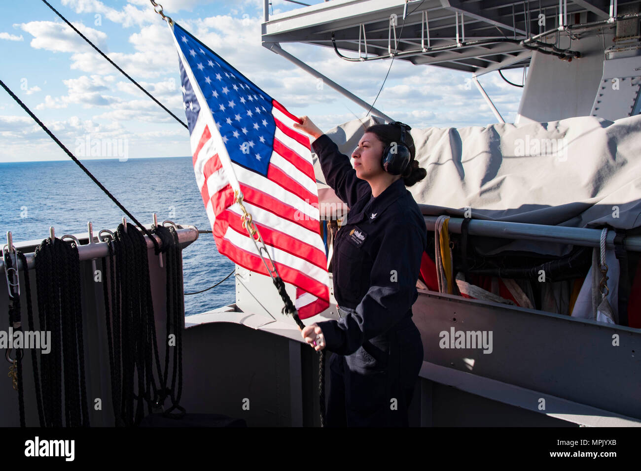 170320-N-KJ380-052 OCEANO ATLANTICO (20 marzo 2017) Intendente di terza classe Dusang Angelle, da New Orleans, si prepara a un paranco il ensign dal segnale rifugio della portaerei USS Dwight D. Eisenhower CVN (69) (IKE). Ike è attualmente conducendo portaerei qualifiche durante la fase di supporto della flotta ottimizzato il piano di risposta (OFRP). (U.S. Navy foto di comunicazione di massa marinaio specialista neo Greene III) Foto Stock