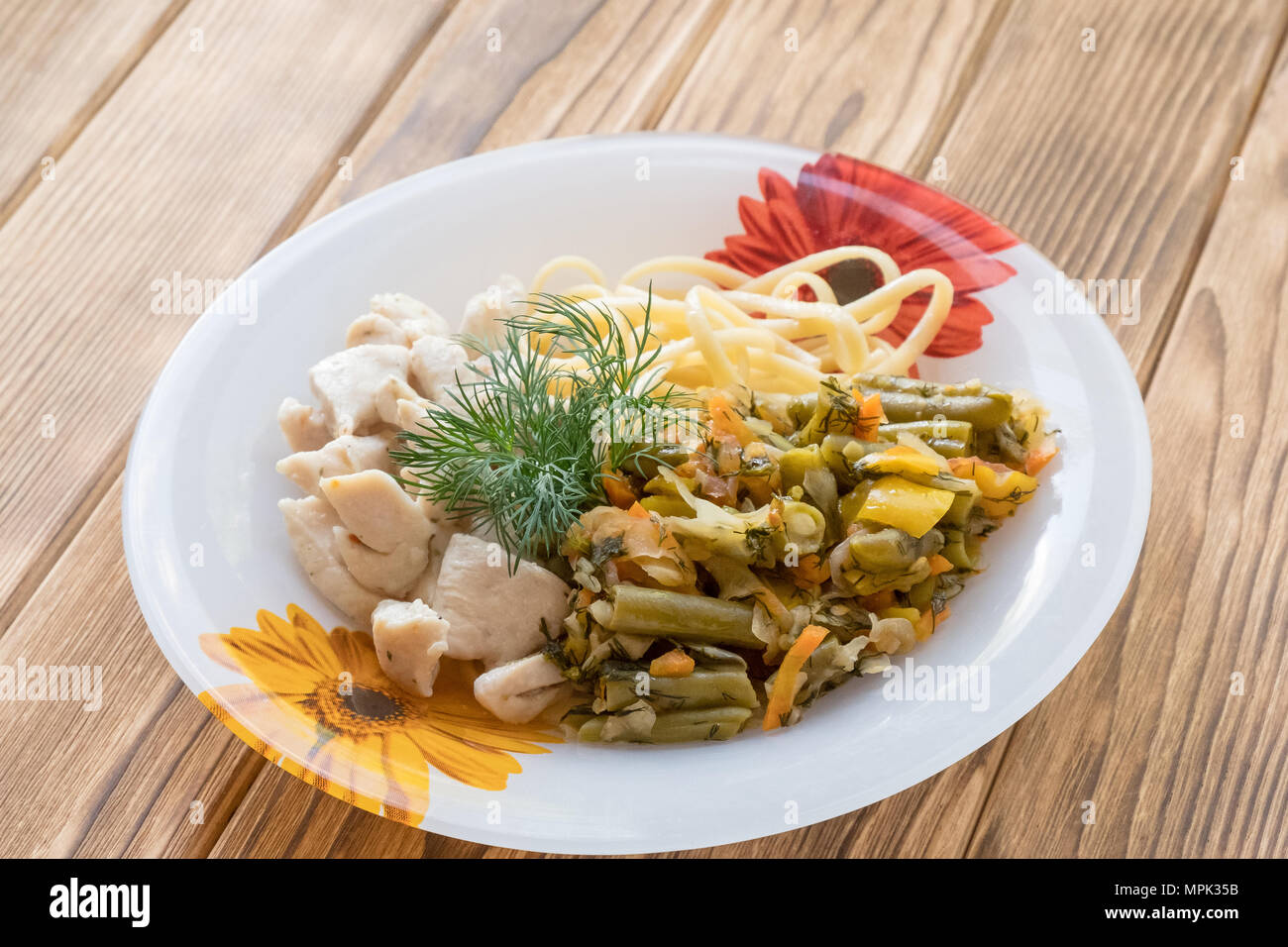 Pezzi di carne di pollo in una piastra con verdure fritte e pasta Foto Stock