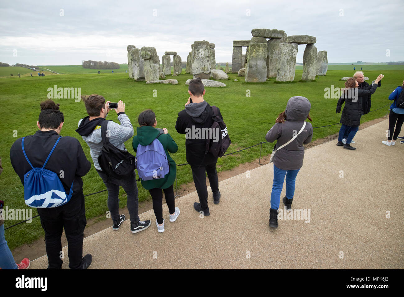 Tour del gruppo di giovani studenti di scattare foto a Stonehenge Wiltshire, Inghilterra Regno Unito Foto Stock
