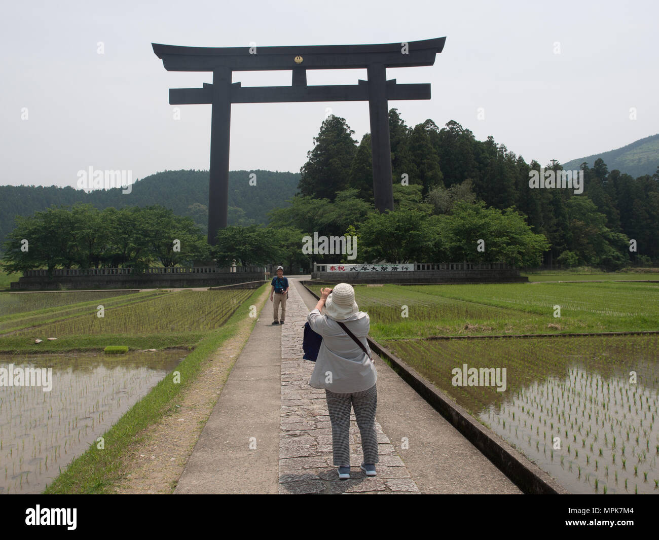 Otorii il cancello di ingresso alla Oyunohara, la posizione originaria di Kumano Hongu Taisha, patrimonio mondiale santuario. Donna Uomo fotografare. Wakayama Giappone Foto Stock
