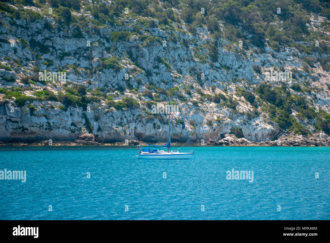 Barca ancorata in cristalline acque blu sul lato NE dell isola di Formentera. Maggio 2018. Foto Stock