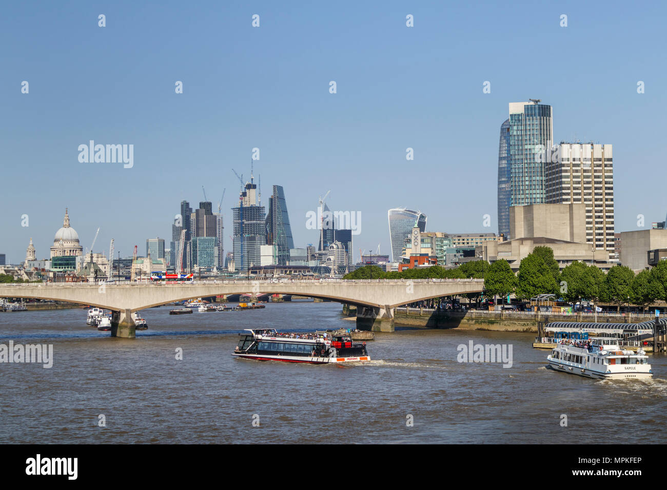 Vista panoramica lungo il fiume Tamigi ponte di Waterloo per l'iconico grattacieli della City di Londra e la Cattedrale di St Paul Foto Stock