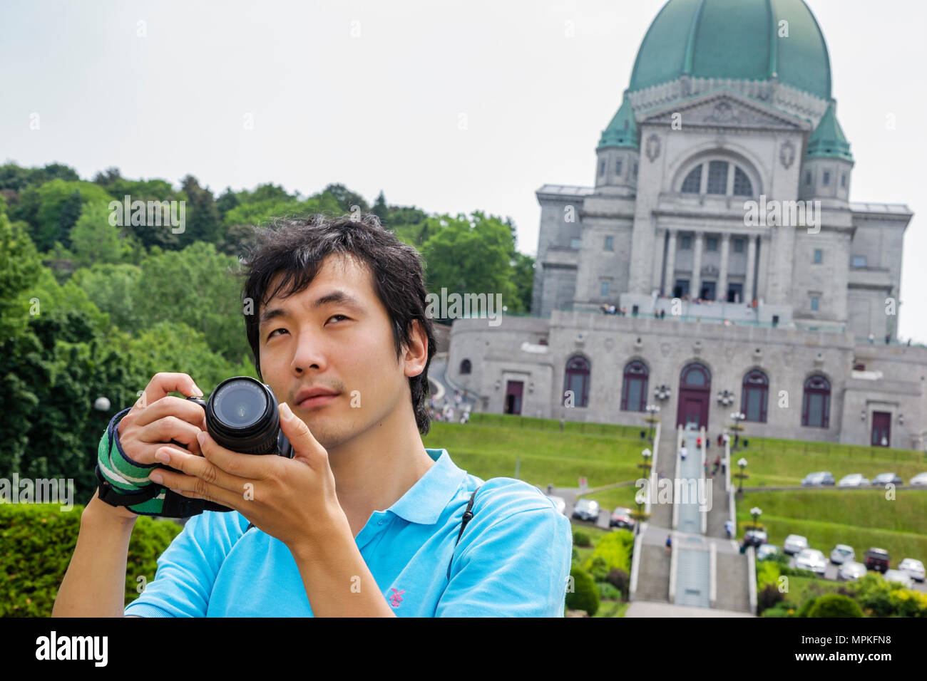 Montreal Canada,Quebec Province,Mont Royal,Saint Joseph's Oratory,Memorial,Catholic,Asian man,maschio students,pupillo,macchina fotografica,digitale,Catholic cour Foto Stock