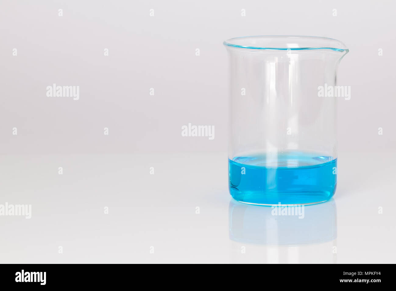 Bicchiere di vetro di soluzione di solfato di rame (cloruro di rame)  liquido blu isolato su bianco riflettente la scienza di sfondo concetto  scientifico Foto stock - Alamy