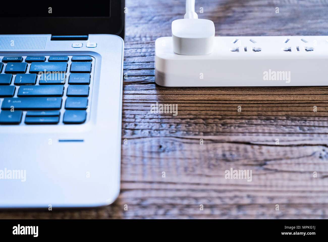 Computer laptop e tappo bianco presa sul legno tavolo di lavoro piatta composizione laici vista superiore con spazio di copia Foto Stock