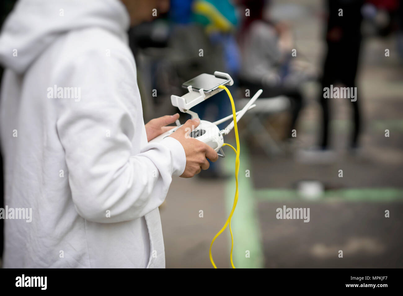 Il dispositivo di controllo remoto, cuffia con smartphone nelle mani di adolescente, giovane uomo close-up, il pilotaggio flying drone. Giocattolo moderno, tempo libero, l'innovazione. Spazio di copia Foto Stock