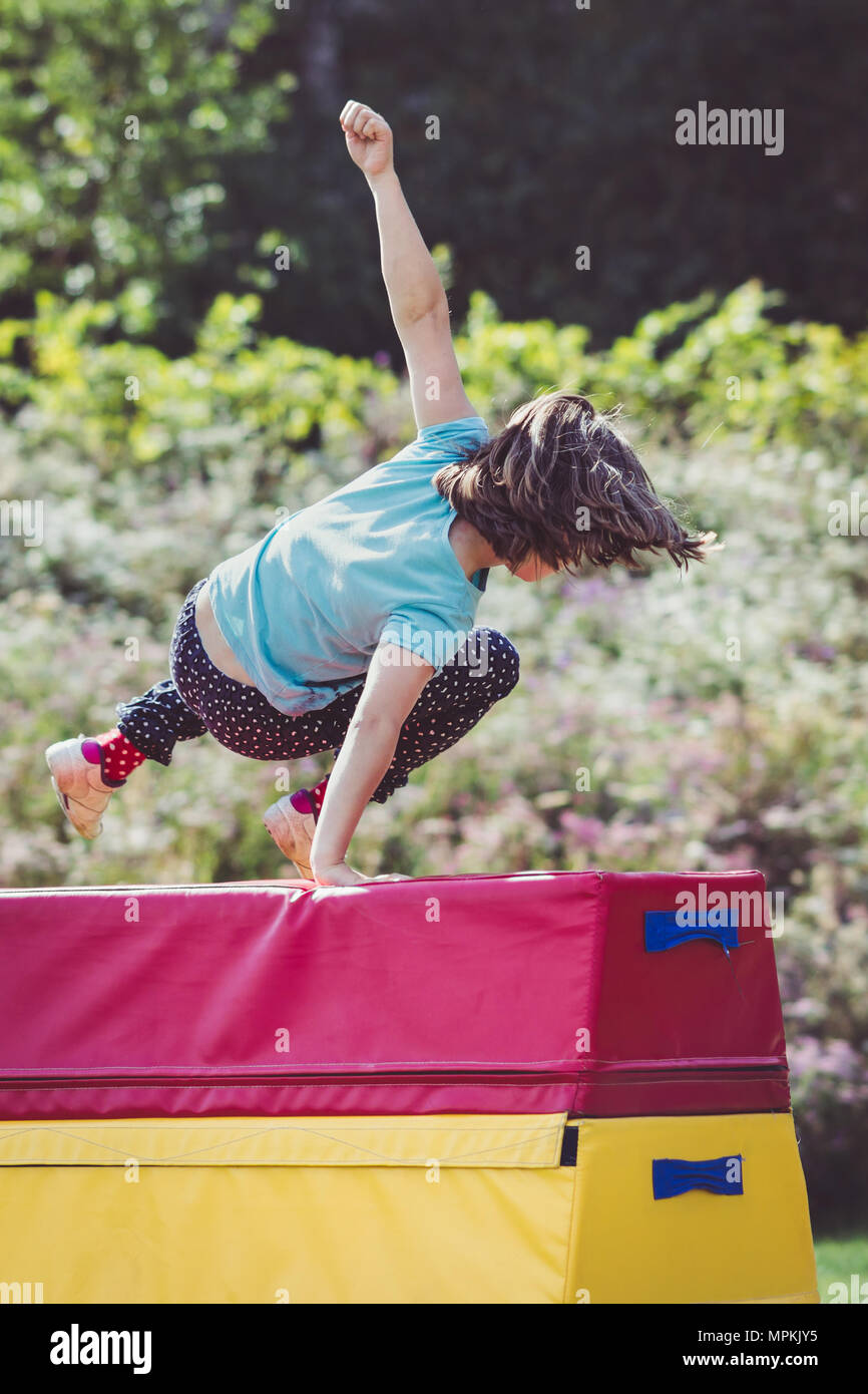 Ragazza bambino la pratica (pratica) ginnastica fuori sul cavallo di Vaulting Foto Stock