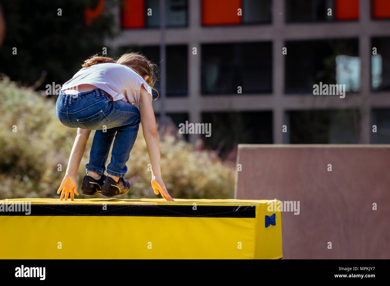 Ragazza bambino la pratica (pratica) Parkour ginnastica fuori sul cavallo di Vaulting Foto Stock