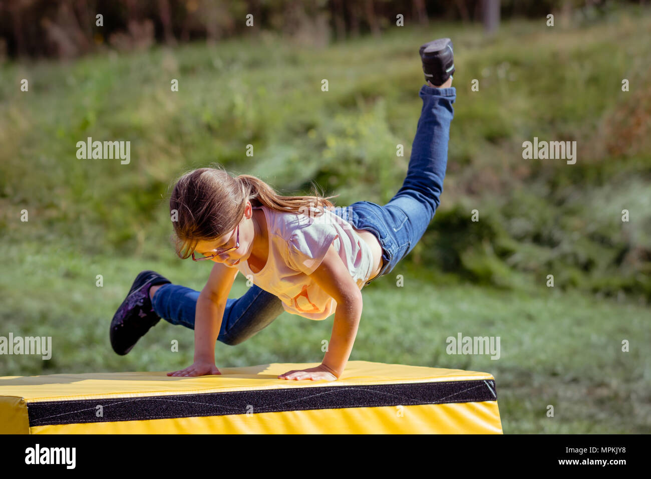 Ragazza bambino la pratica (pratica) Parkour ginnastica fuori sul cavallo di Vaulting Foto Stock