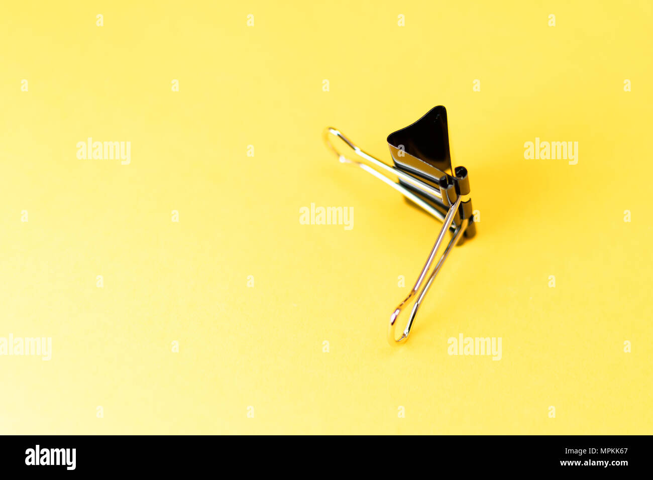 Chiuso clip legante sul lato e su sfondo giallo Foto Stock