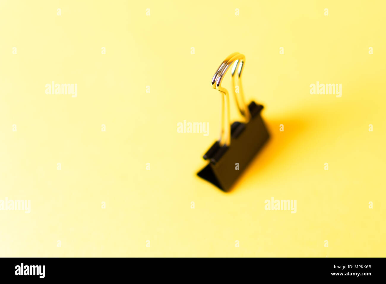 Chiuso clip legante in piedi su sfondo giallo Foto Stock