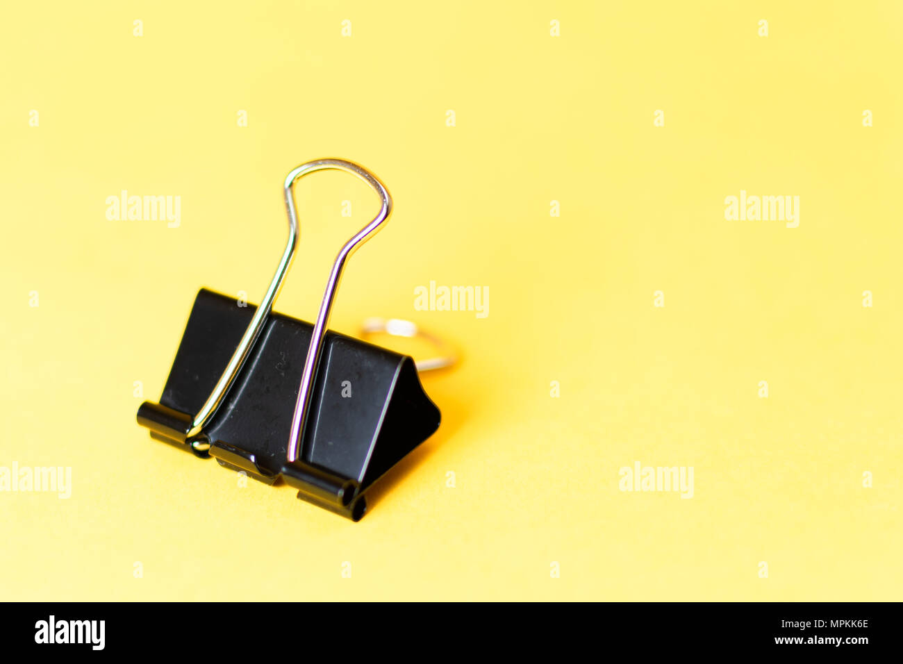Chiuso clip legante sul lato e su sfondo giallo Foto Stock