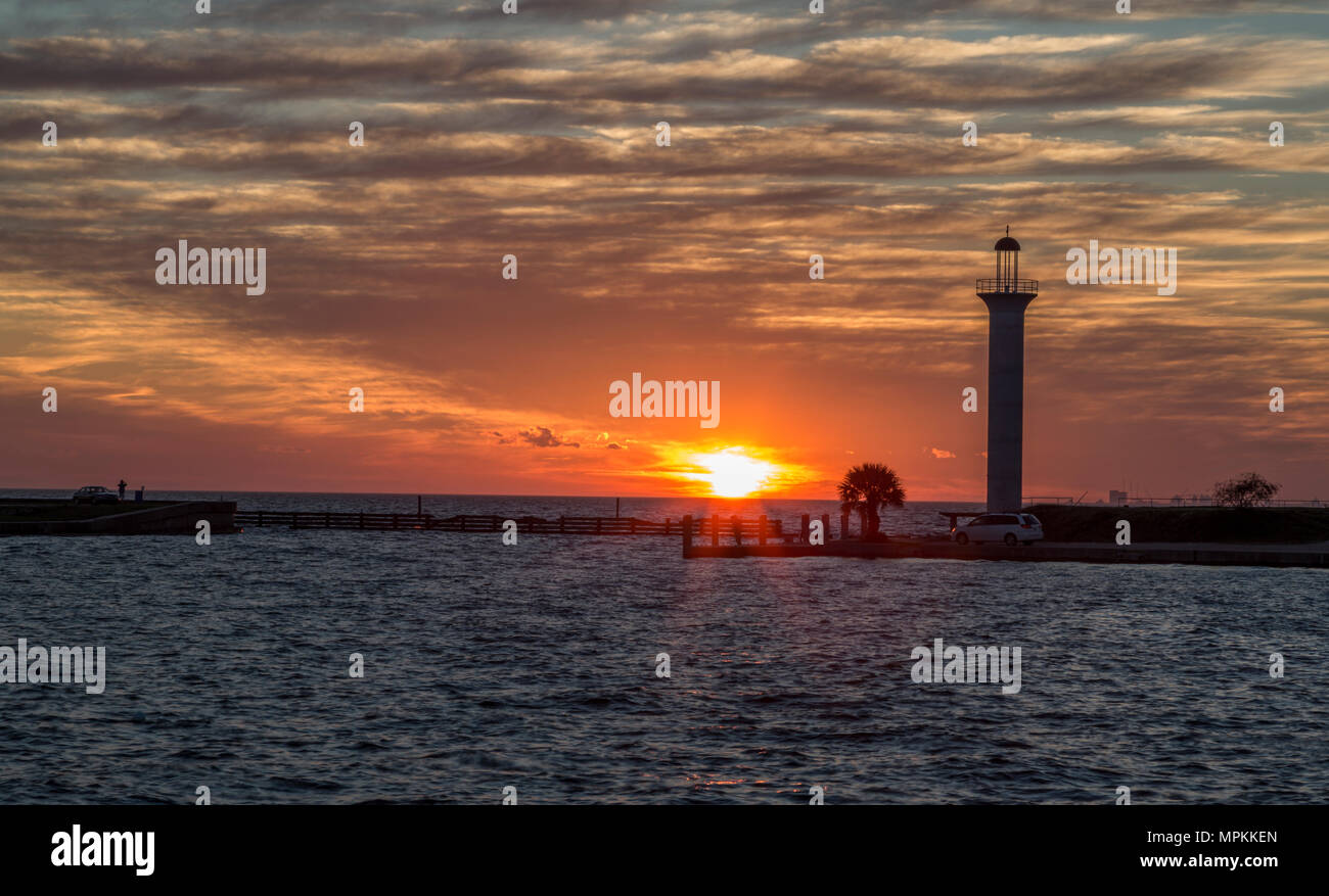 Il sole si trova dietro il faro di Broadwater lungo la costa del Golfo del Mississippi a Biloxi, Mississippi Foto Stock