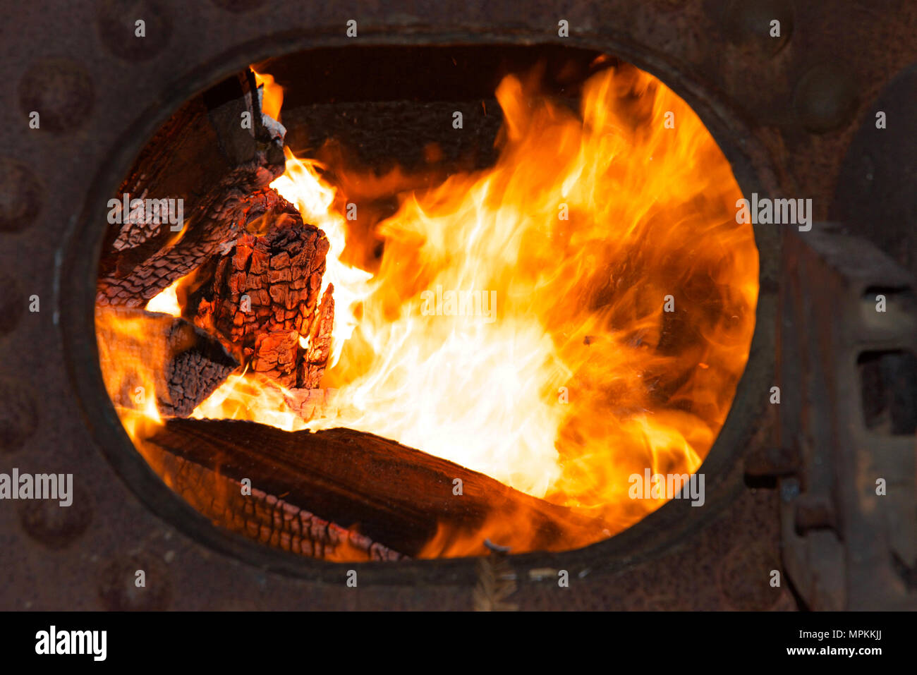 Fuoco in un metallo una caldaia a vapore per produrre energia per far funzionare il legname di apparecchiature di mulino. Legname di scarto dal mulino fornisce una fonte di combustibile per la cottura di t Foto Stock