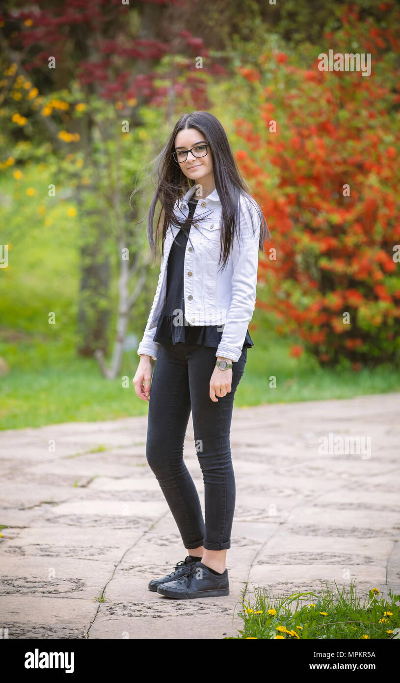 Ragazzo cerca ragazza in telecamera. All'esterno Ritratto di giovane e bella bruna ragazza nel parco. Foto Stock