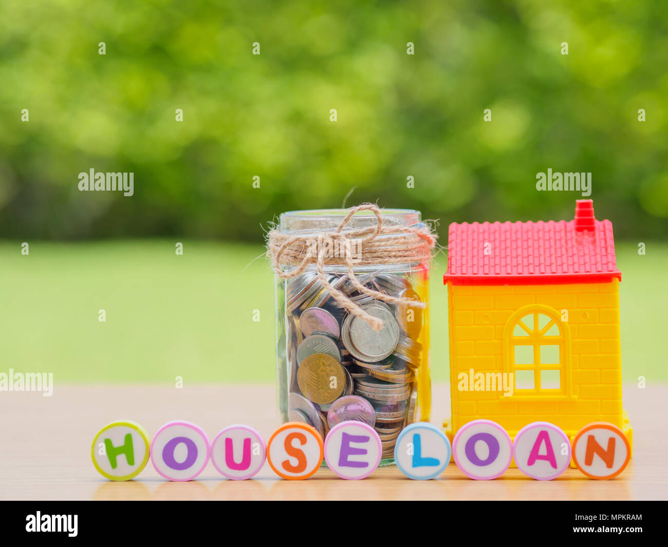 Monete in vaso con red house. Il risparmio per home concetto Foto Stock
