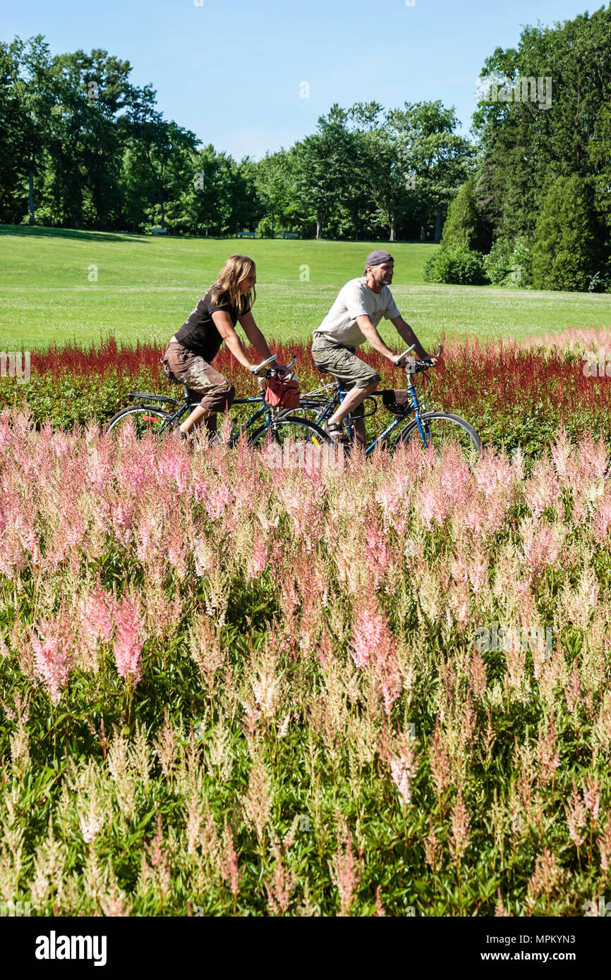 Quebec Canada,Parc du Bois de Coulonge,parco pubblico,coppia,uomo uomini maschio,donna donna donne,bicicletta,bicicletta,equitazione,ciclismo,rider,percorso ciclabile,fiore,fiore Foto Stock