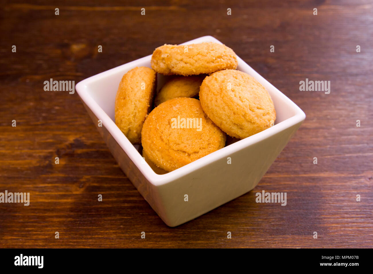 Biscotti farciti sul recipiente quadrato su una tavola di legno Foto Stock