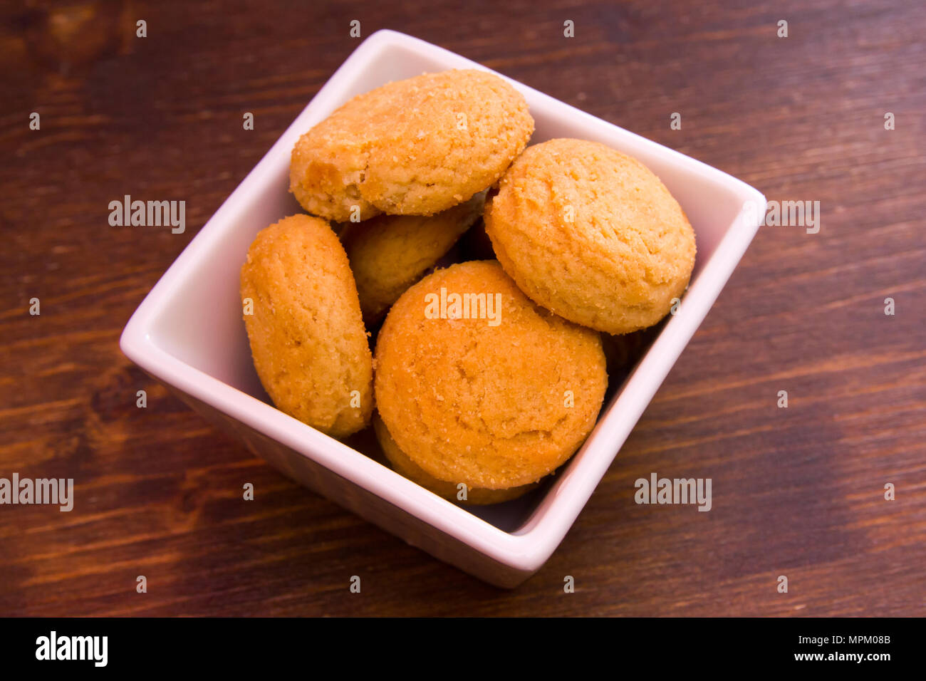 Biscotti farciti sul recipiente quadrato su una tavola di legno visto da vicino Foto Stock