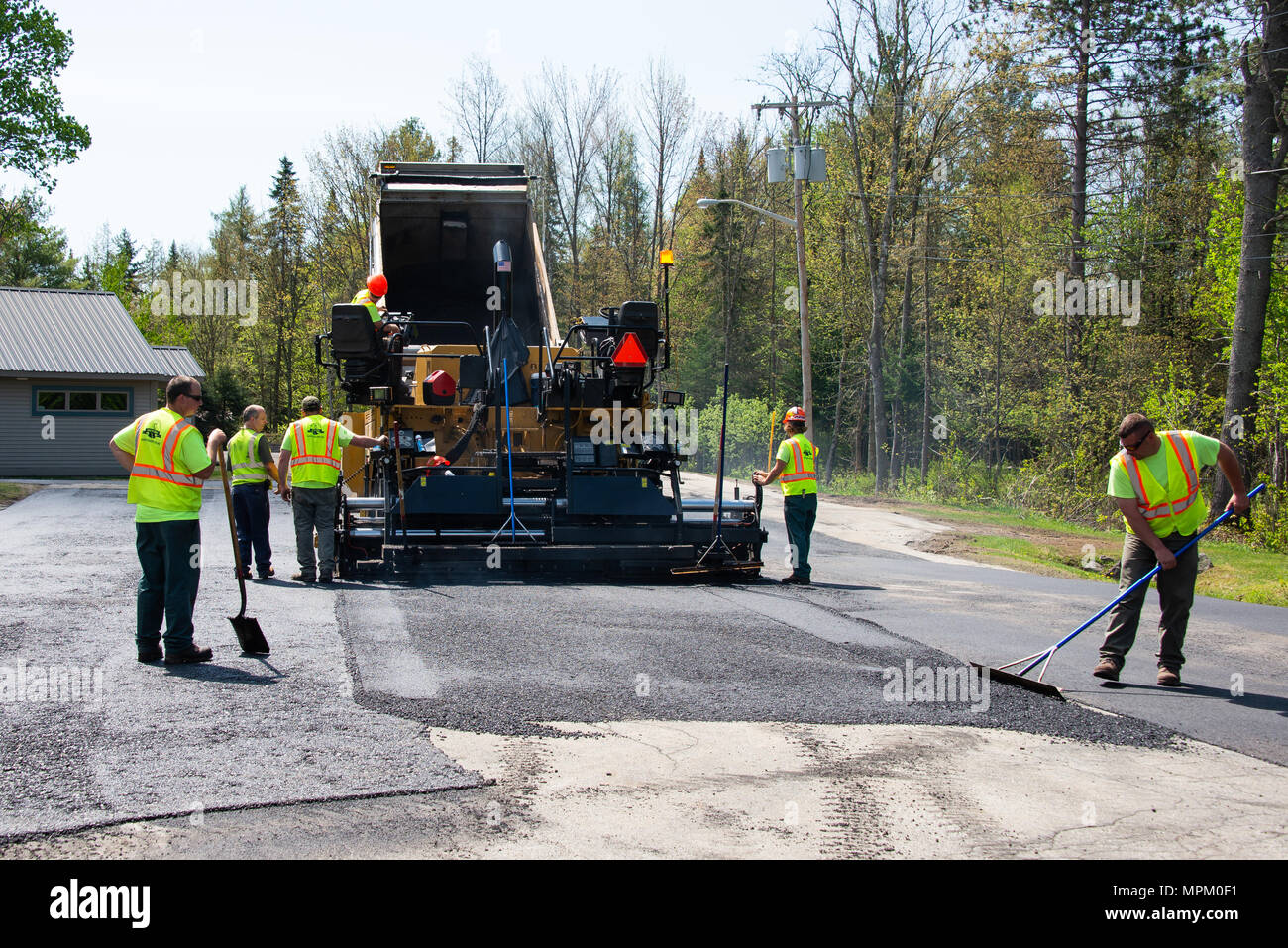 Un autocarro con cassone ribaltabile e strada lastricatore posa di asfalto su un parcheggio in speculatore, NY USA Foto Stock