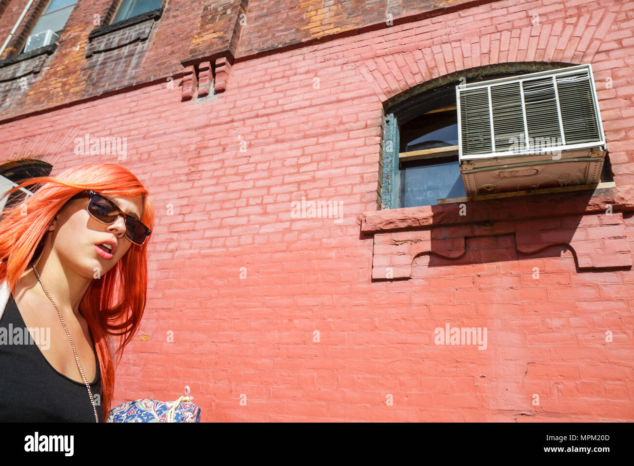 Toronto Canada,Peter Street,adulti donna donna donna donna donna donna donna donna donna donna donna donna donna donna donna donna donna donna donna donna donna donna donna, muro di mattoni rossi,capelli tinti,giovane adulto,trendy,occhiali da sole,finestra,aria condizionata unità,A Foto Stock