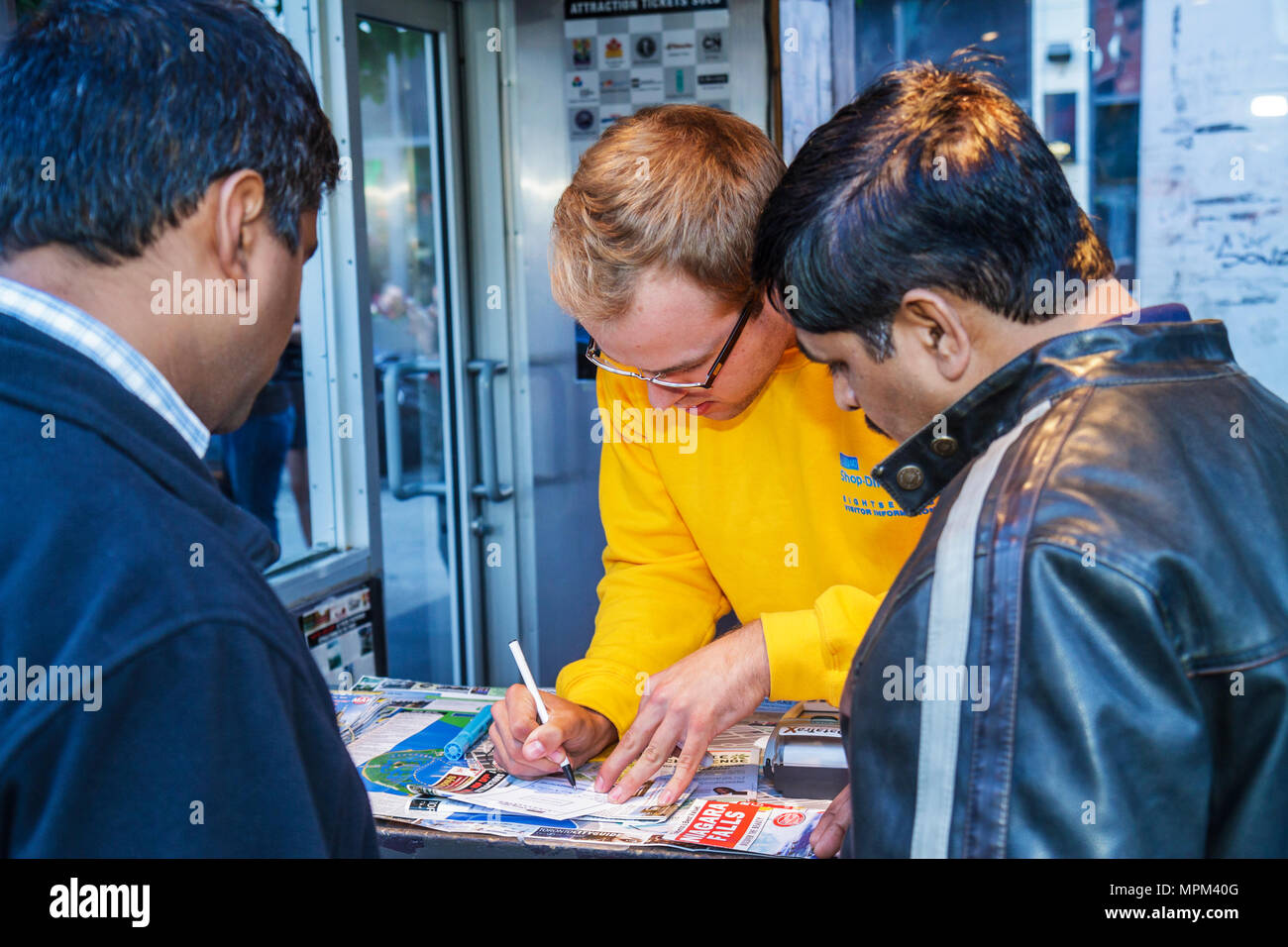 Toronto Canada,Yonge Street,Dundas Square,Visitors Information,stand,stand,chiosco,Asian Asian Asian Asian Asian Aethnic immigranti minoranza,uomo uomini maschio adulto Foto Stock