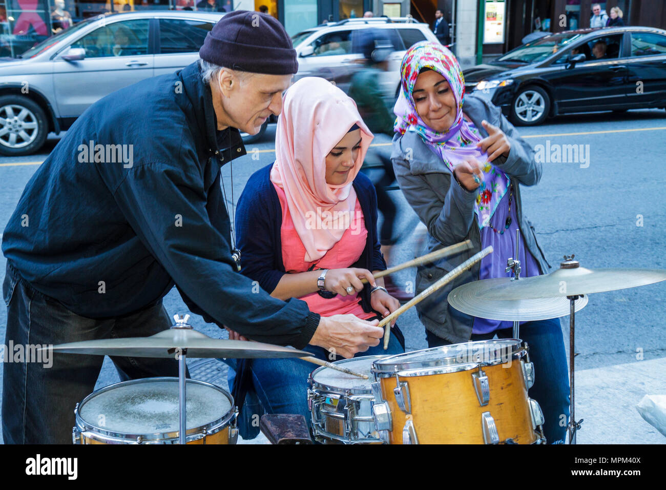 Toronto Canada,Yonge Street,Dundas Square,musicista di strada,insegnamento,musulmano,Islam,asiatici asiatici immigrati etnici minoranza,adulti donna w Foto Stock