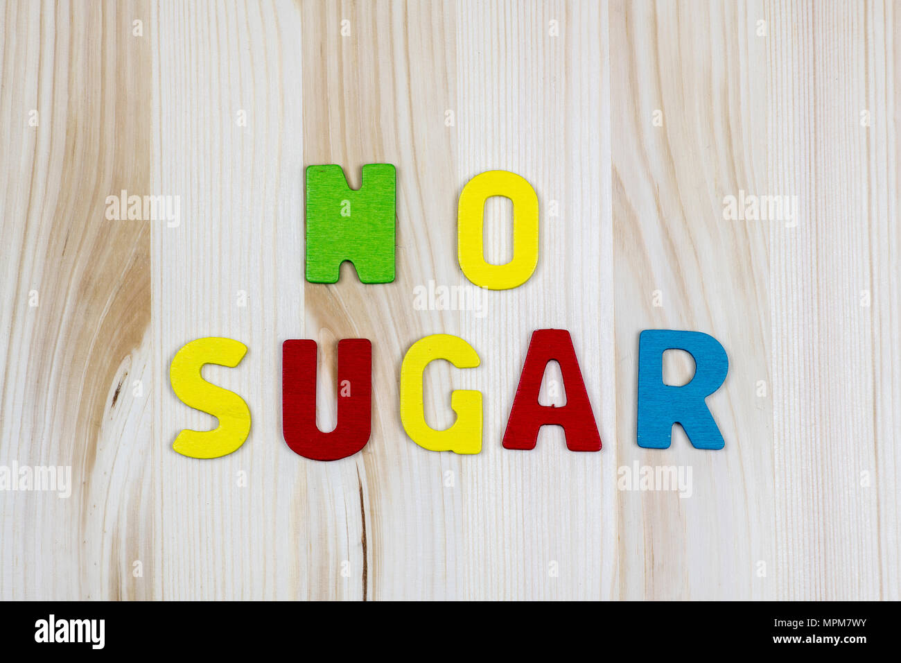 NIENTE ZUCCHERO! in lettere di legno colorate su un tavolo di legno, promuovere uno stile di vita senza zucchero per migliorare la salute e il benessere, concetto di salute Foto Stock