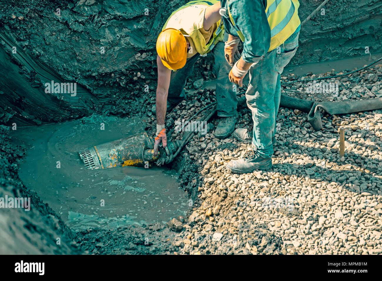 Pompaggio di acqua di inondazione, pompa sommergibile dewater sito in costruzione. Effetto colore. Foto Stock