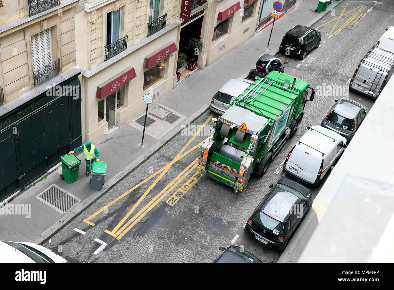 Scomparto di verde per raccolta rifiuti vista di camion su strada guardando verso il basso sulla uomini al lavoro di raccolta rifiuti Rifiuti Rifiuti in Parigi Francia Europa KATHY DEWITT Foto Stock