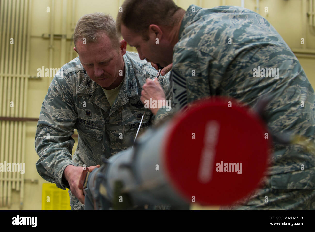 Stati Uniti Air Force Col. Giuseppe McFall, 52nd Fighter Wing il comando e Chief Master Sgt. Edwin Ludwigsen, 52nd FW command chief, costruire un'aria di intercettare il missile 9 durante una leadership di Saber "fuori e circa" evento a Spandgdahlem Air Base, Germania, 27 marzo 2017. La cinquantaduesima squadrone manutenzione munizioni sezione fornisce tutti gli esplosivi della cinquantaduesima FW per includere i missili, le bombe guidate, 20 mm munizioni pistola, Pula/flare, contromisure e pratica bomba unità fittizia 33 bombe.(STATI UNITI Air Force foto di Senior Airman Alba M. Weber) Foto Stock