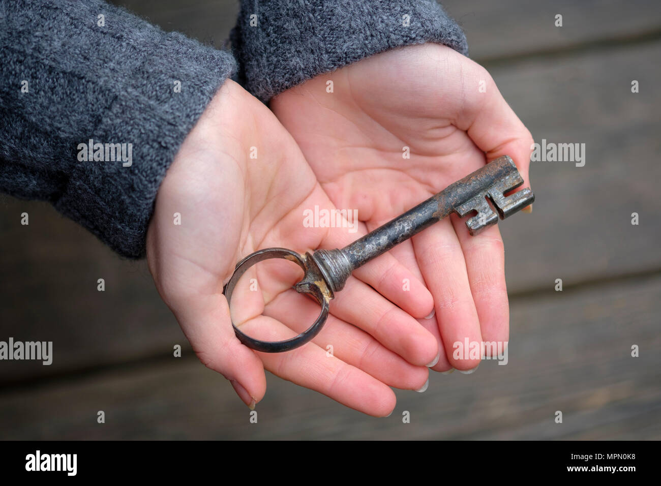 Mani tenendo una vecchia chiave, close-up Foto Stock