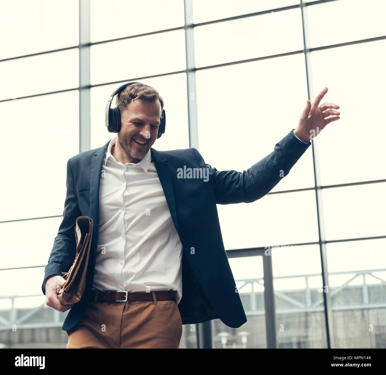 Happy businessman ascolto di musica con cuffie Foto Stock