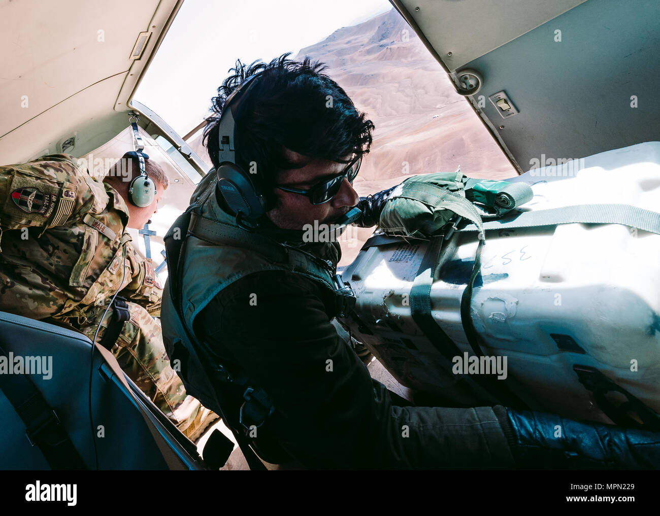 Un Afghan Air Force Stati formazione con treno, consulenza, assistenza Command-Air, come parte del sostegno deciso la missione, funziona in tandem con un consulente di mettere in pratica le gocce d'aria vicino a Kabul, Afghanistan, Marzo 19, 2017. Il TAAC-consulenti di aria di promuovere rapporti di lavoro e fortificare la fiducia nella missione. (U.S. Air Force foto di Senior Airman Giordania Castelan) Foto Stock