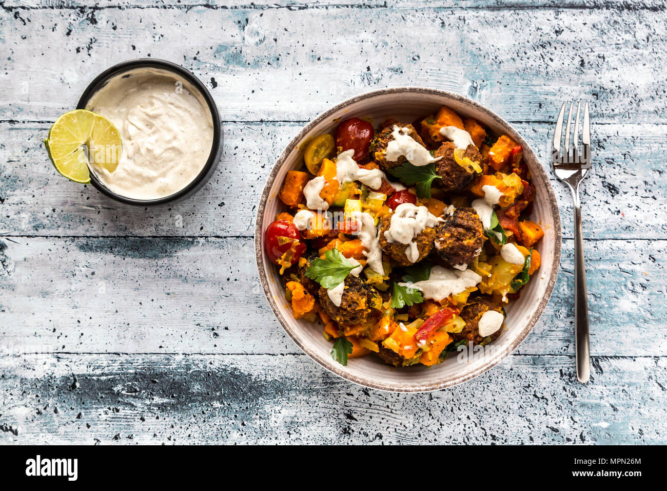 Ciotola vegetariano con dolce di patata e di pomodoro e i falafel, yogurt dip e prezzemolo Foto Stock