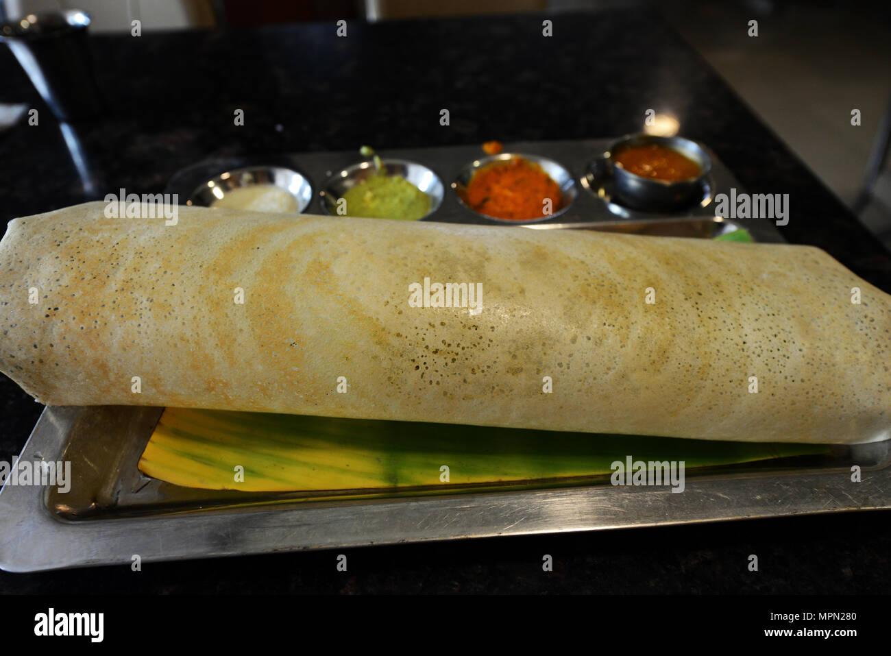 Una piastra di Masala dosa con quattro diverse mostarde. Foto Stock