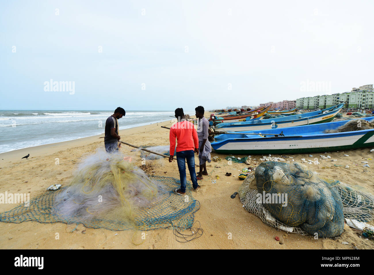 I pescatori e barche di pescatori sulla spiaggia di Marina di Chennai, India. Foto Stock