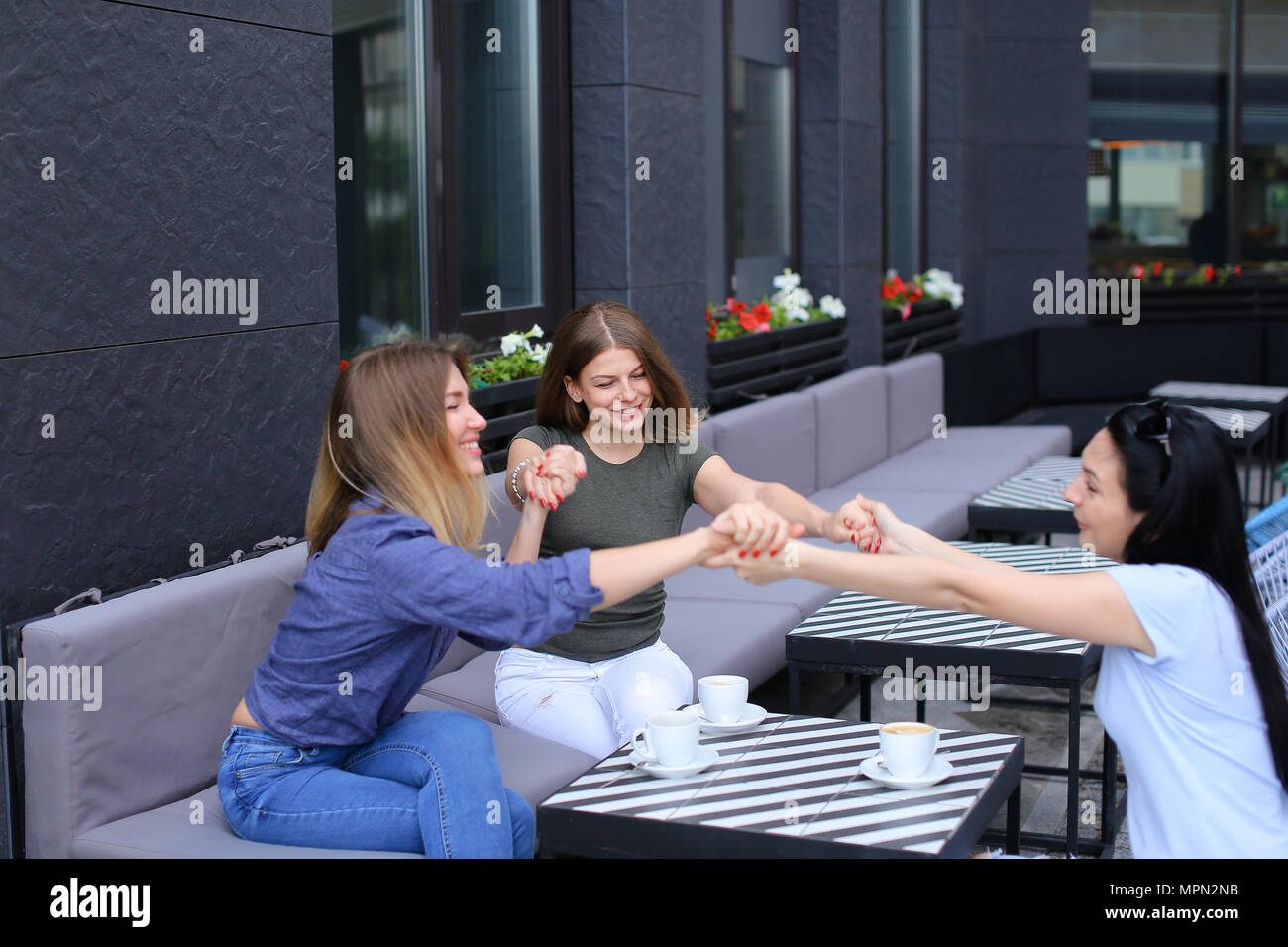 Amici di sesso femminile seduto presso il cafe e tenendo le mani. Foto Stock