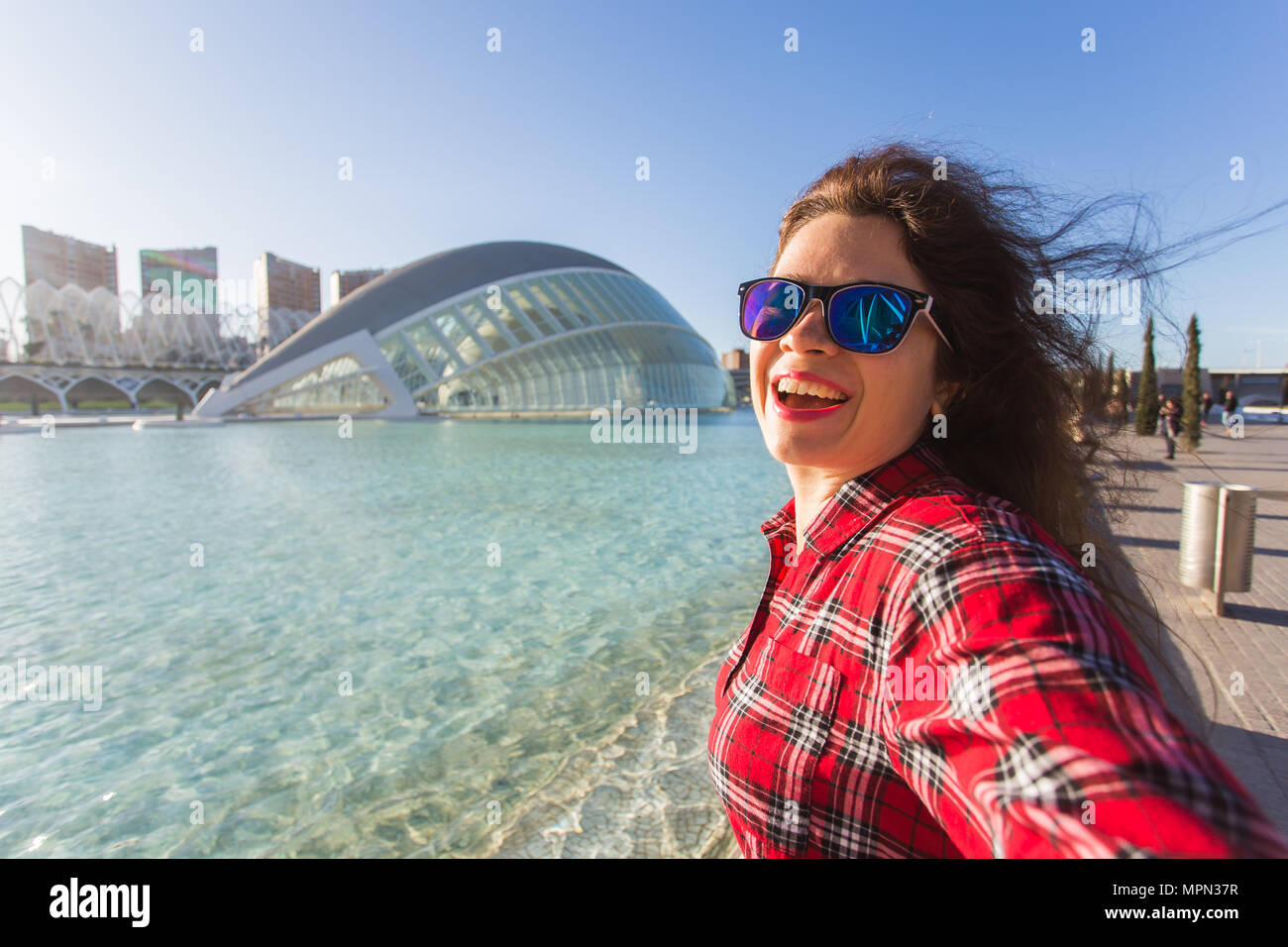 Valencia, Spagna, Gennaio, 01, 2018, giovane donna rende selfie sullo sfondo dell'Hemisferic edificio nella Città delle Arti e delle Scienze di Valencia, Spagna. Foto Stock