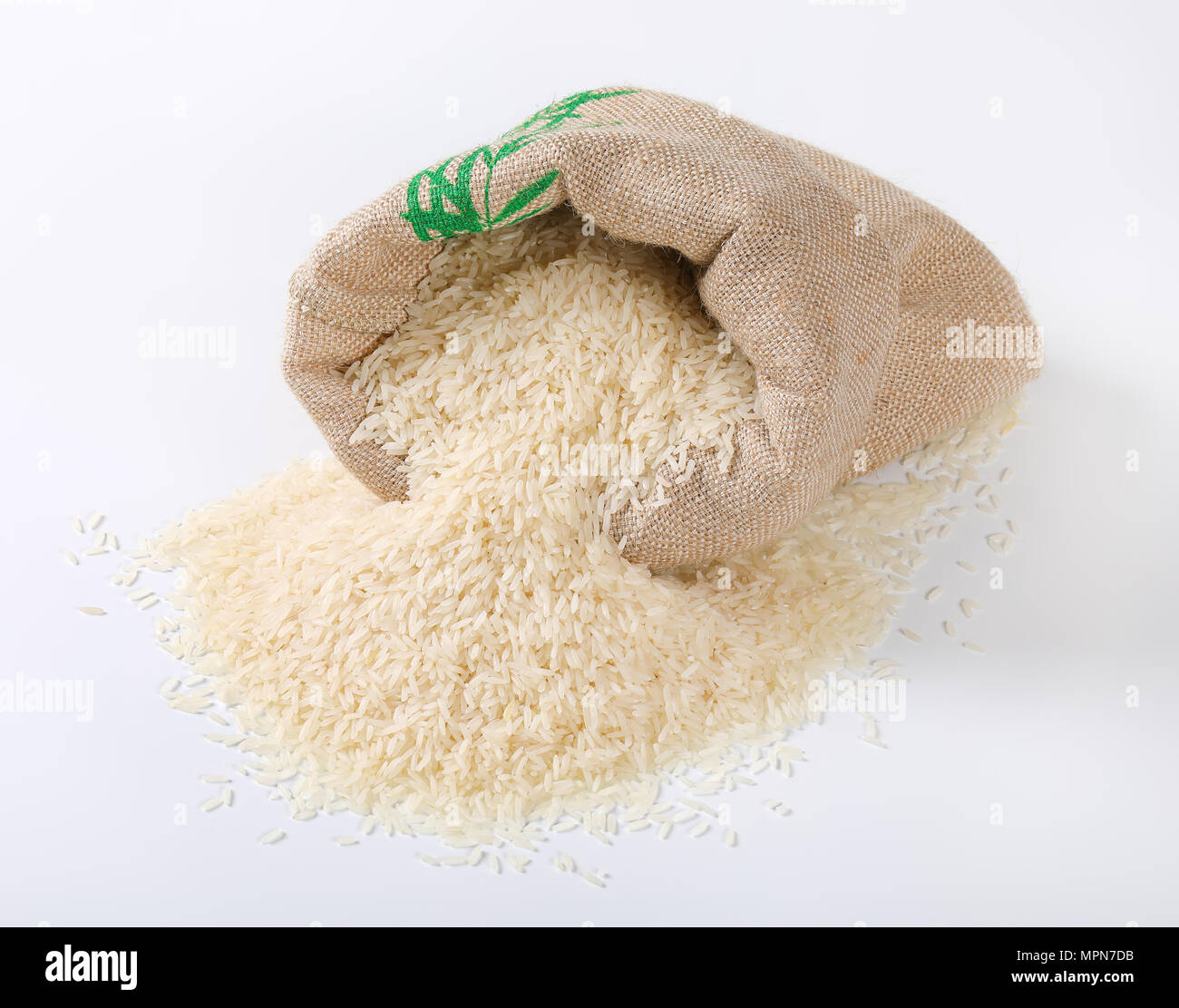 Borsa e pila di bianco a grana lunga riso su sfondo bianco Foto Stock